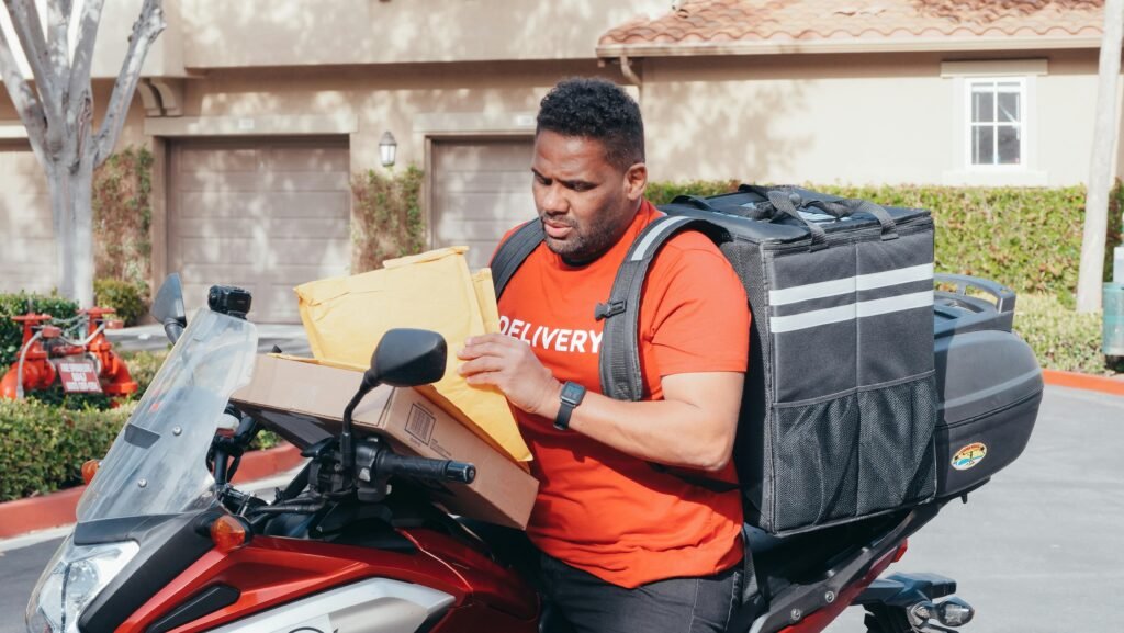 Man delivering parcels on a motorbike, illustrating the efficiency of package delivery services.